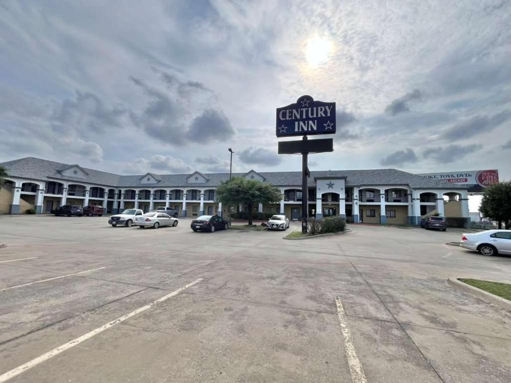 a building with a sign in a parking lot at Century Inn in Dallas