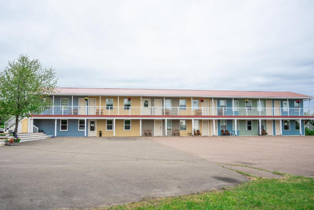 a large building with a parking lot in front of it at Bouctouche Bay Inn in Bouctouche