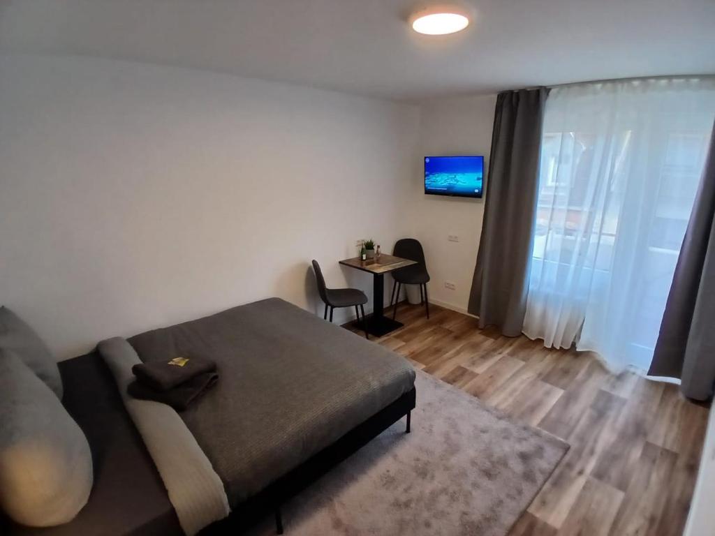 a bedroom with a bed and a table with chairs at City Hub Room 22 - mit Balkon - Coffee for free - in Karlsruhe