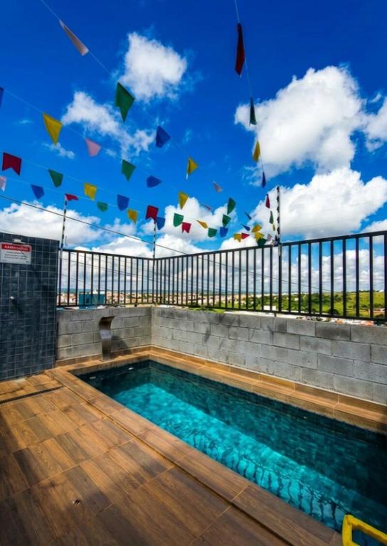 a swimming pool with flags flying in the sky at Apto Completo São João com Garagem e Piscina in Campina Grande