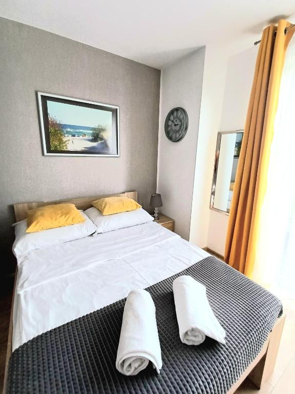 a bedroom with a large white bed with towels on it at Willa Arkadia w Pucku in Puck