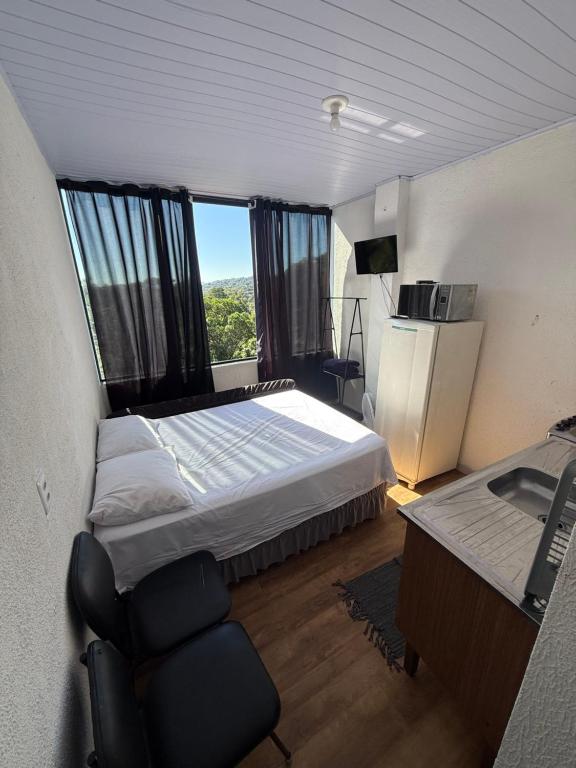 a bedroom with a bed and a desk and a window at Lindo Apto Mobiliado, Smart TV - Caieras in Caieiras