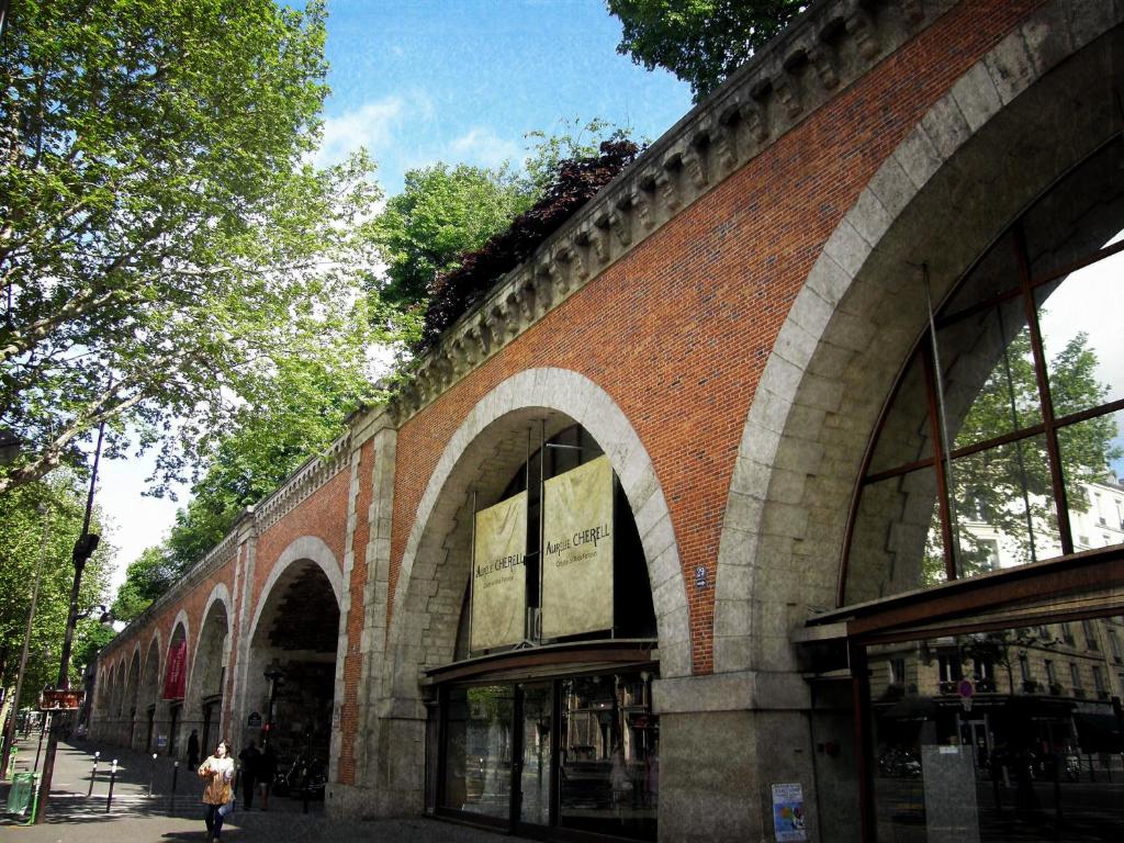 a brick building with arches on the side of it at Aligre in Paris