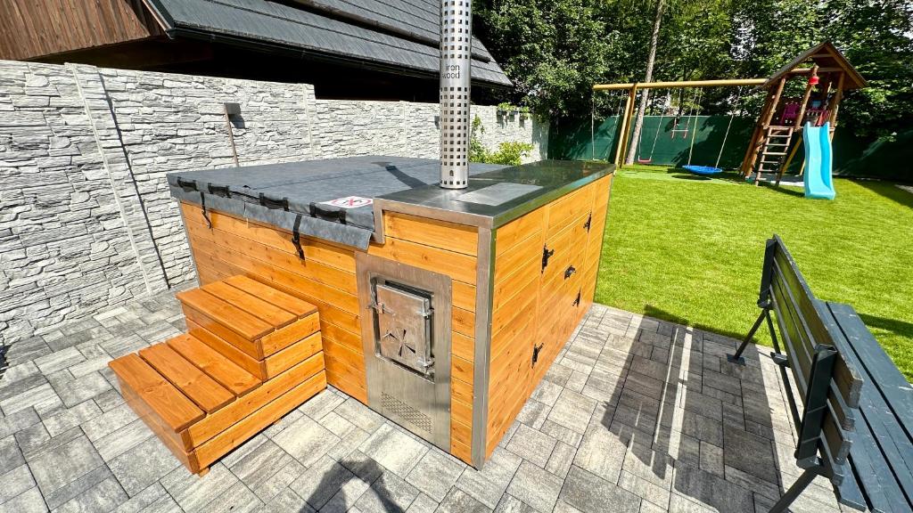 a woodburning stove in a backyard with a playground at Chalupa Martinček in Terchová