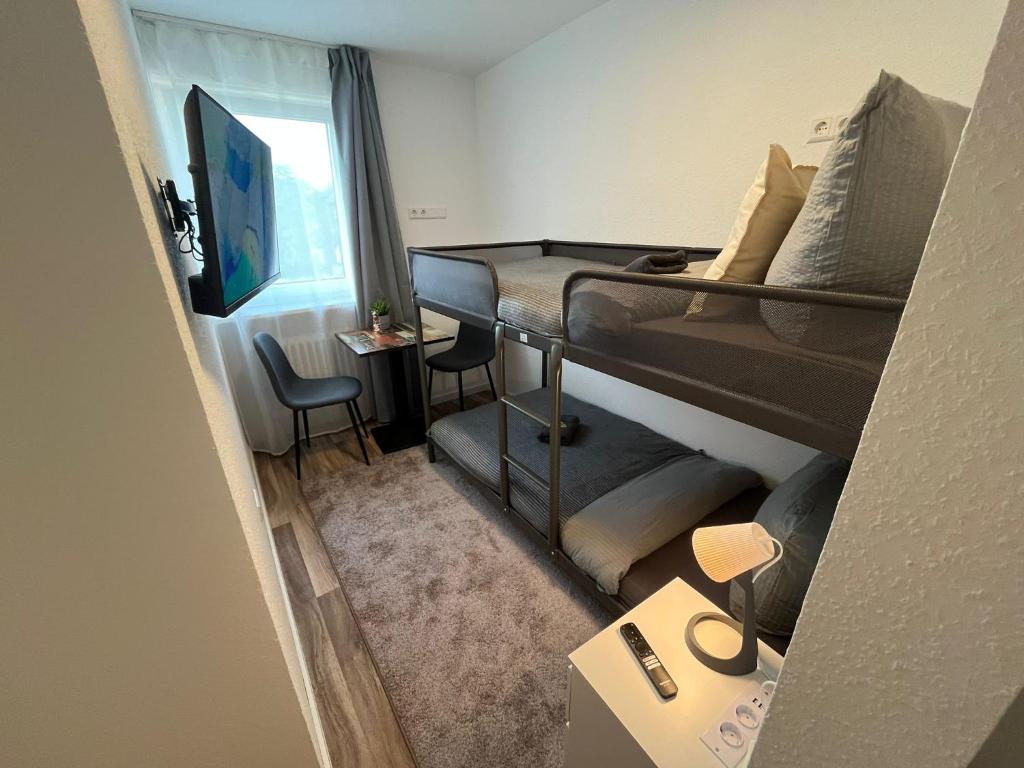 a small room with two bunk beds and a desk at City Hub Room 27 - Coffee for free - in Karlsruhe