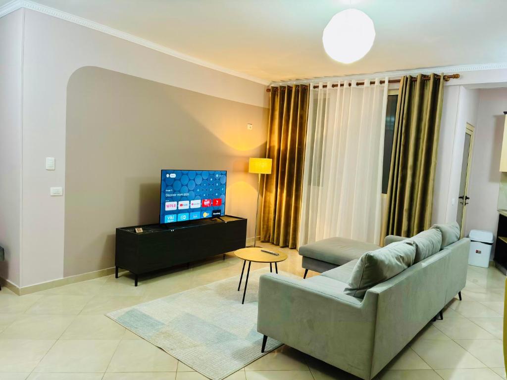 a living room with a couch and a tv at Arc Apartment Family - City Center in Divjakë