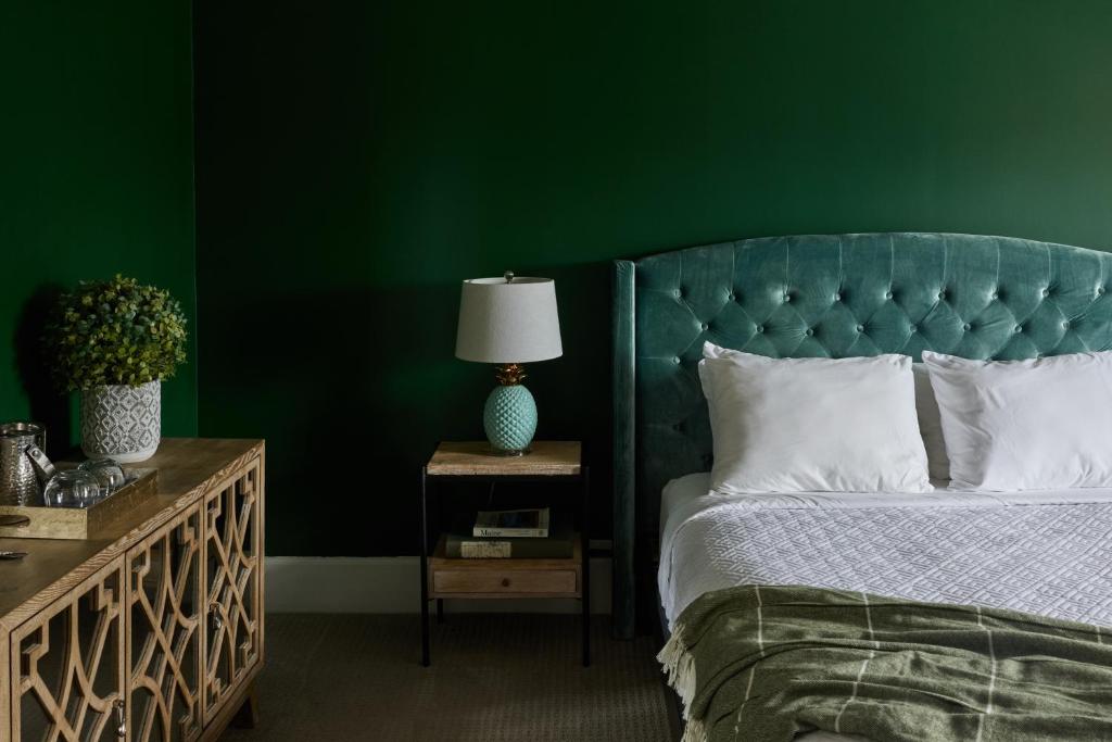 a green bedroom with a bed and a green wall at The West End Collection on Pine in Portland