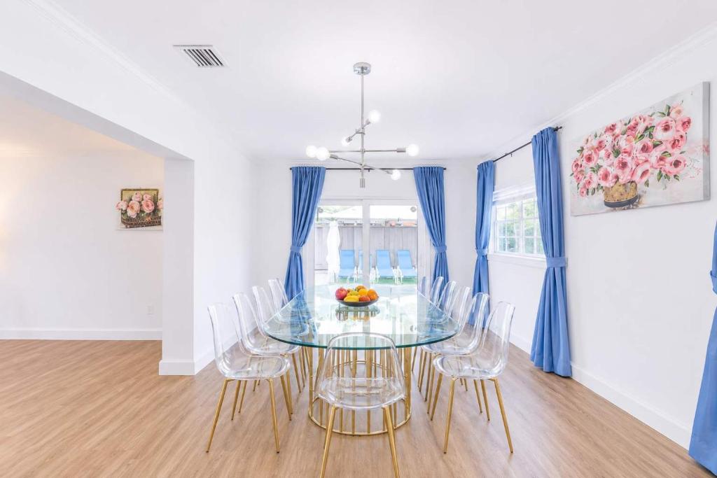 a dining room with a glass table and chairs at The Golfstream Dunes Villa in Hallandale Beach