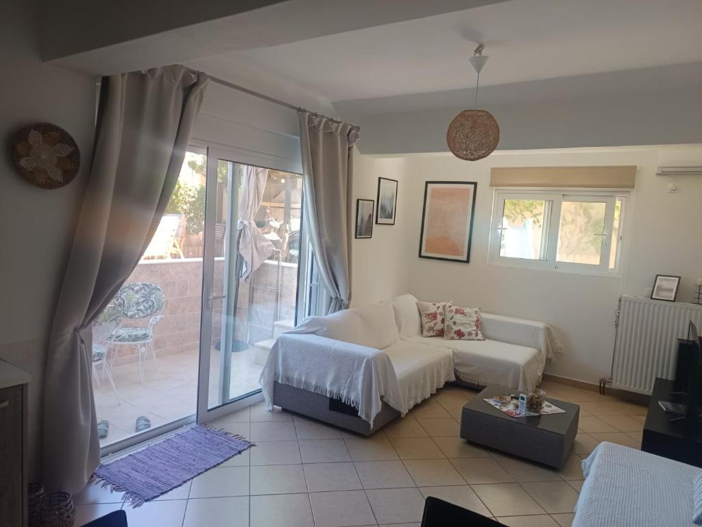 a living room with a couch and a window at Airport Anasta Casa in Artemida