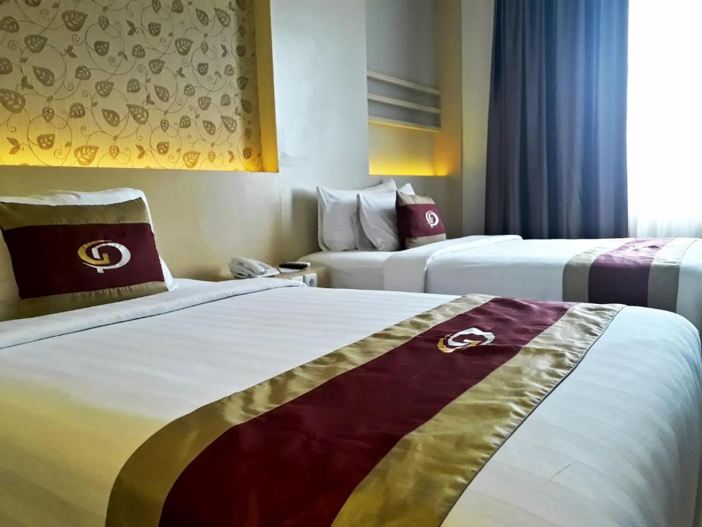 Postel nebo postele na pokoji v ubytování Grand Parama Hotel