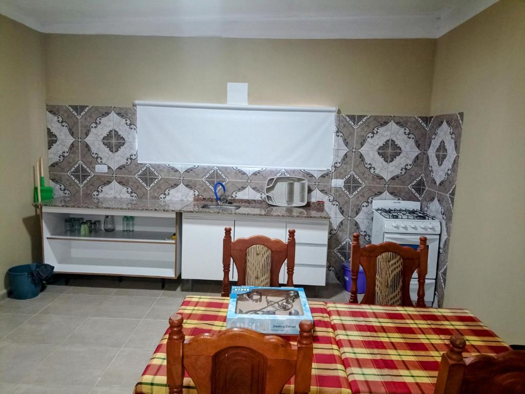 a kitchen with a table and two chairs and a stove at Atardecer serrano in Mina Clavero