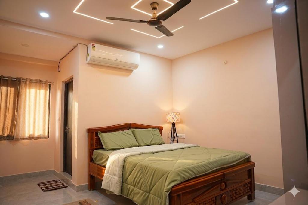 a bedroom with a bed with a ceiling fan at The jaish heaven in Rushikonda