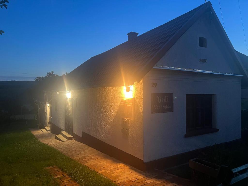 a white building with the sun shining on it at Bedi Vendégház in Nagybakónak