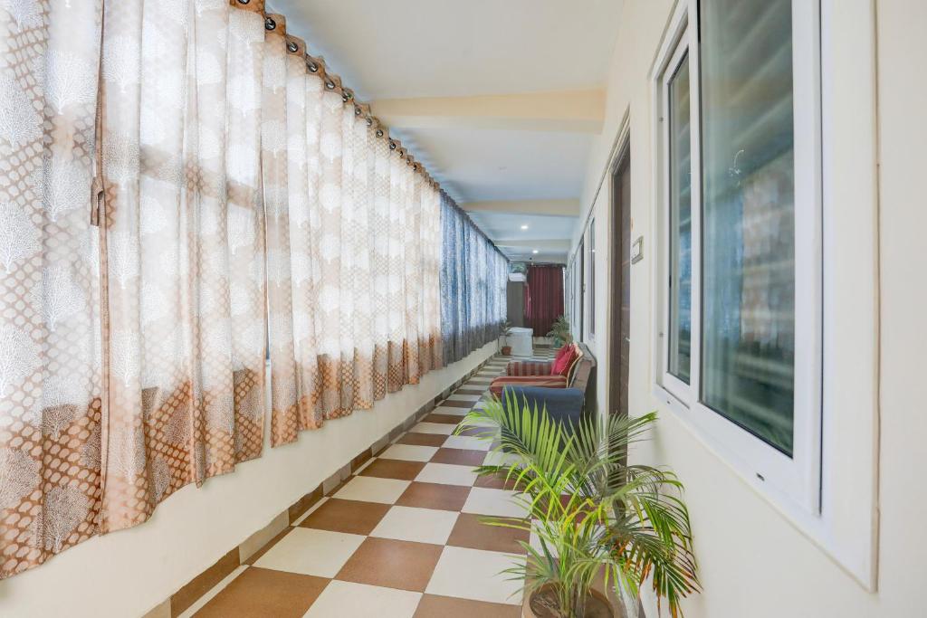 a hallway with a checkered floor and plants at Hotel O Aqua Comforts in Yelahanka
