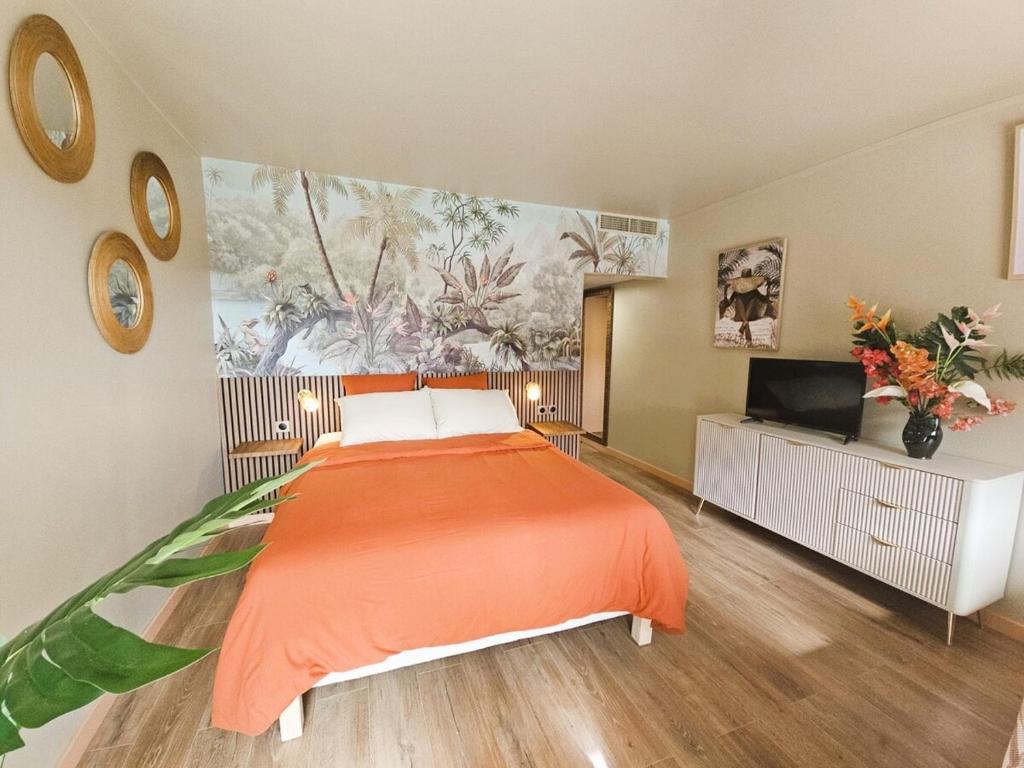 a bedroom with a bed with an orange blanket at Tropical Chic Studio - Marina View - Swimming Pool in Les Trois-Îlets