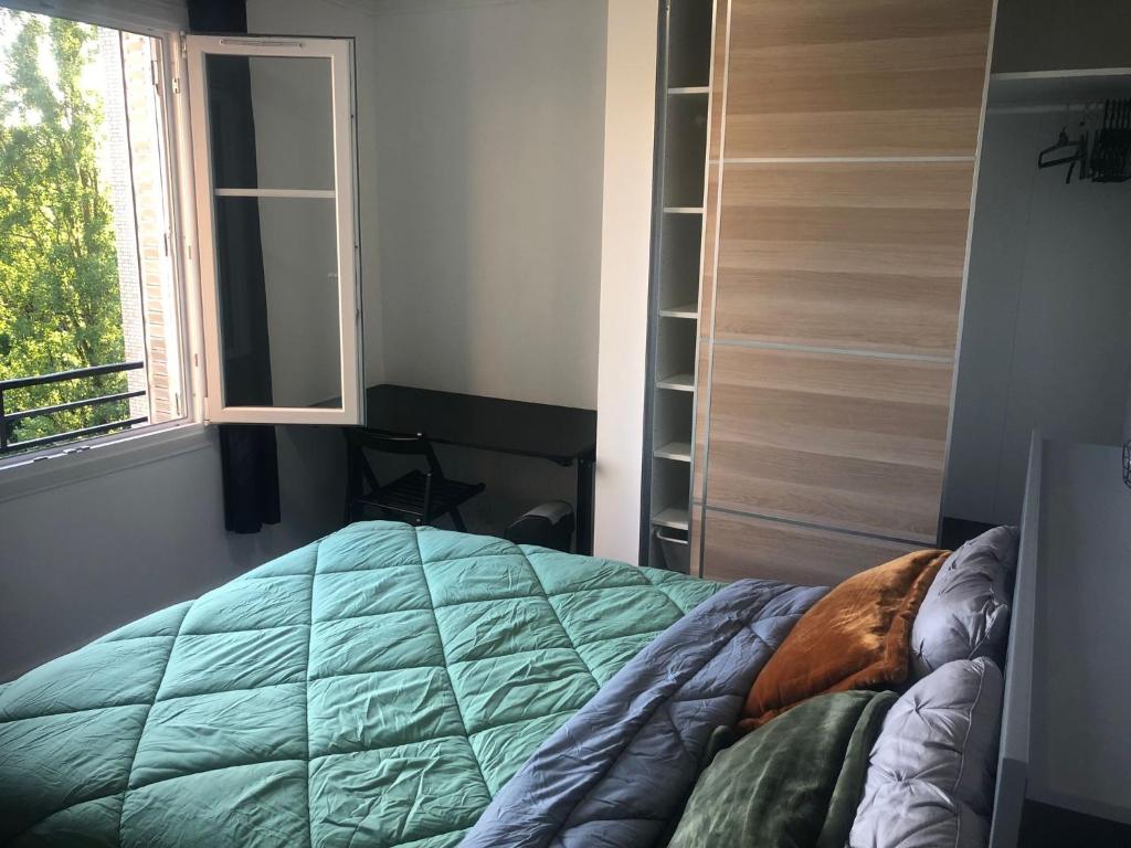 a bedroom with a bed and a window at Near Paris in Ris-Orangis