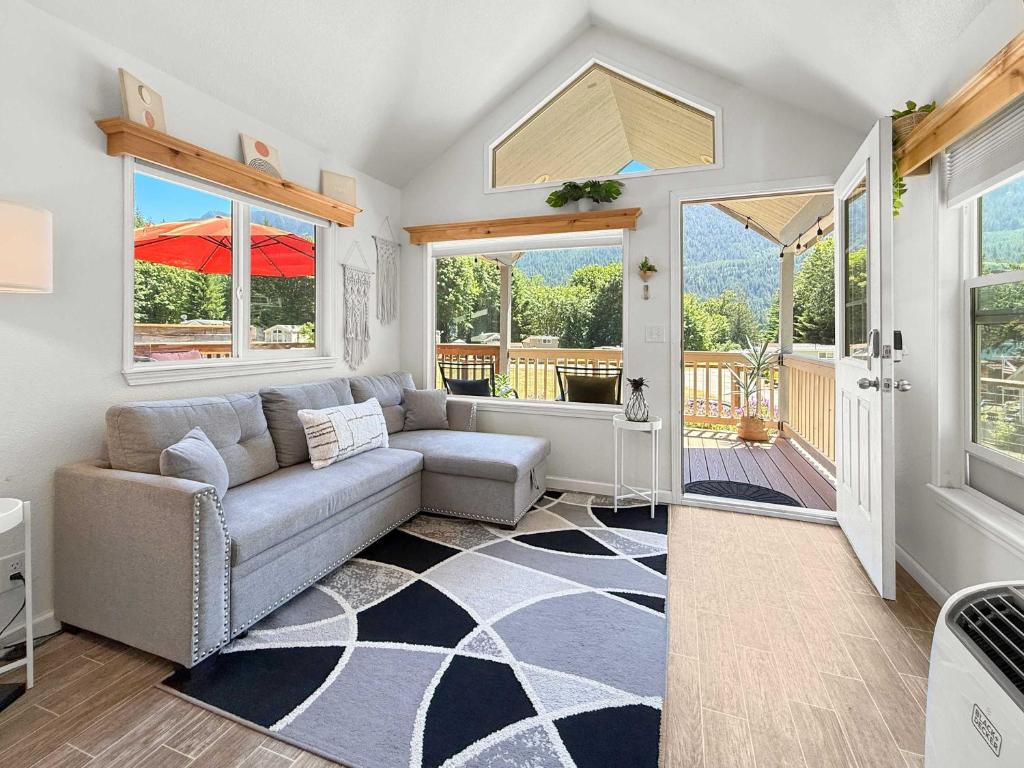 a living room with a couch and a porch at Lake Sutherland Chalet Tiny home with lake access in Port Angeles