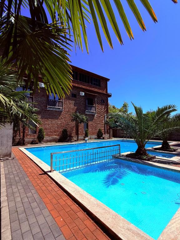a large blue swimming pool next to a building at Hotel Like Mari in P'ichvnari