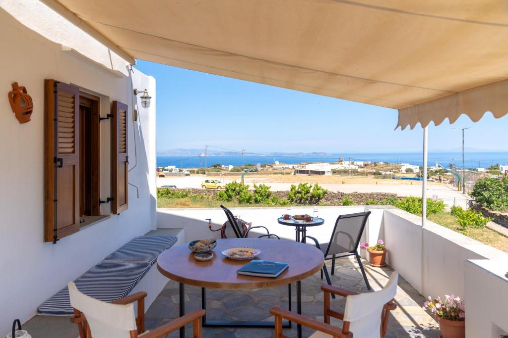 a patio with a table and chairs on a balcony at Flo Guest House in Sifnos