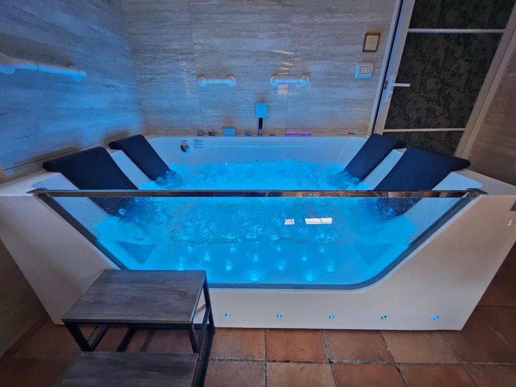 a tub in a room with chairs and a table at Montefiori Luxury Suite & Spa in Bologna