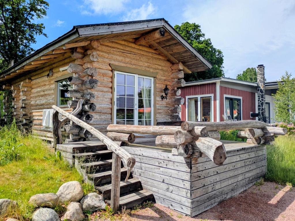 a log cabin with a staircase leading to the front door at Cozy Lakeside Adventure - Biberburg am See in Osby