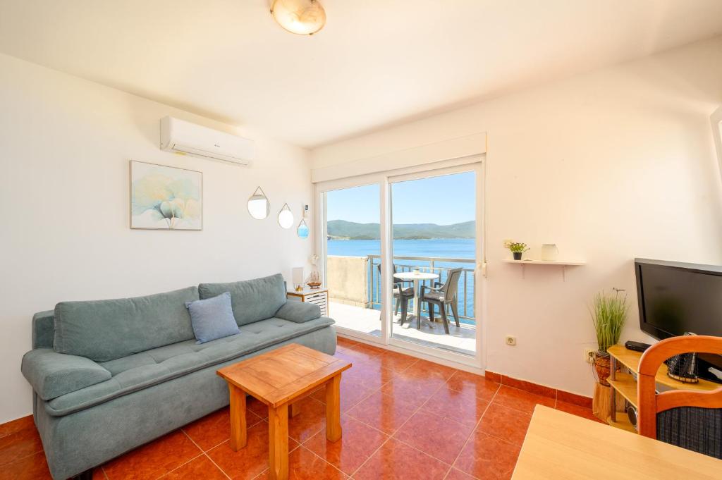 a living room with a couch and a television at Holiday Home in Komarna