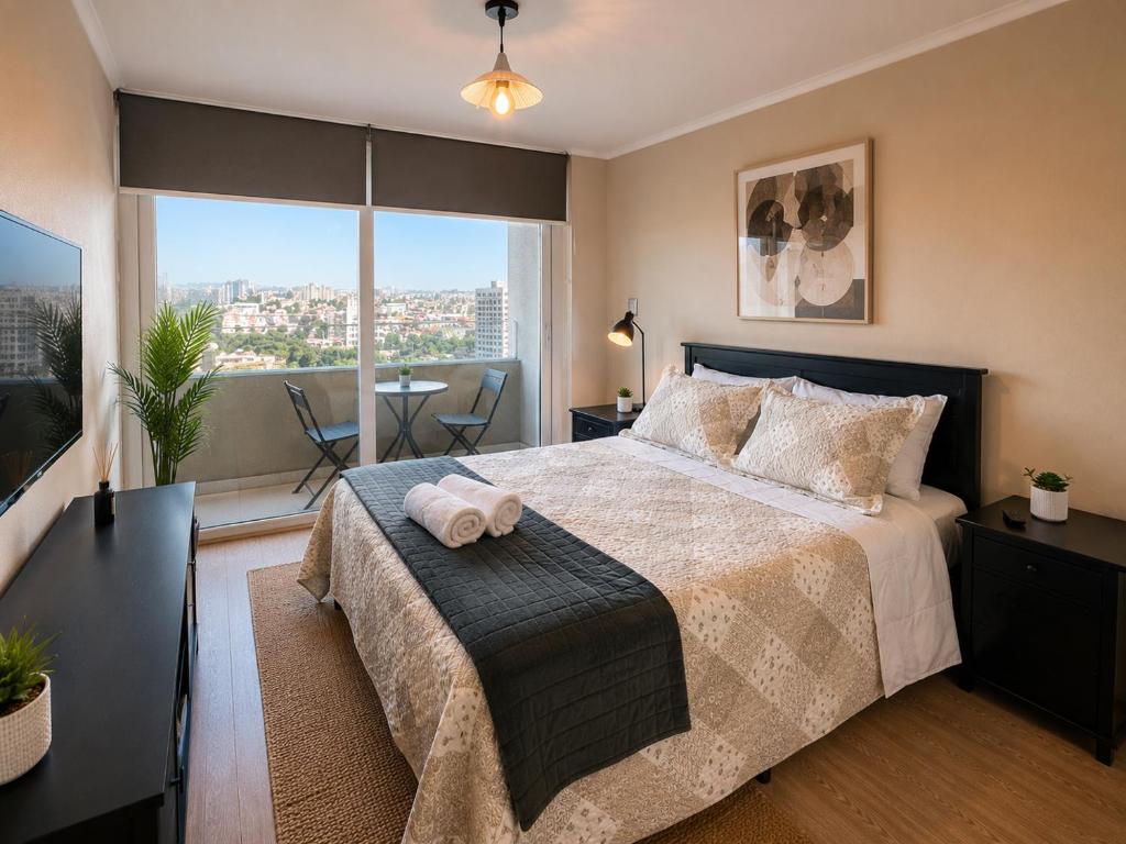 a bedroom with a large bed with a large window at Alto Arrayán II in Osorno