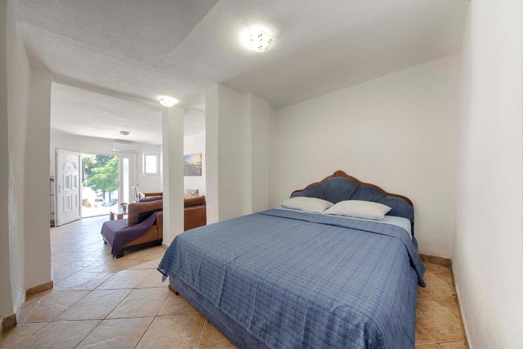 a bedroom with a bed with a blue comforter at FIRST ROW Sea View in Šušanj
