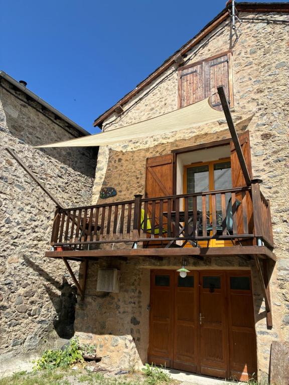 a house with a balcony on the side of it at La grange un refuge in Mijanès