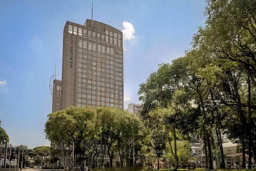 a tall building with trees in front of it at VM Flats Guarulhos Aeroporto in Guarulhos