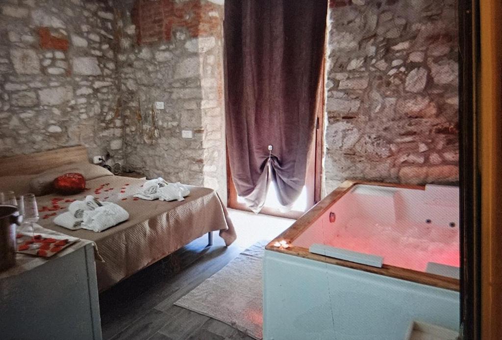 a bedroom with a bed and a tub in a room at Podere il Gallo Agriturismo in Campiglia Marittima