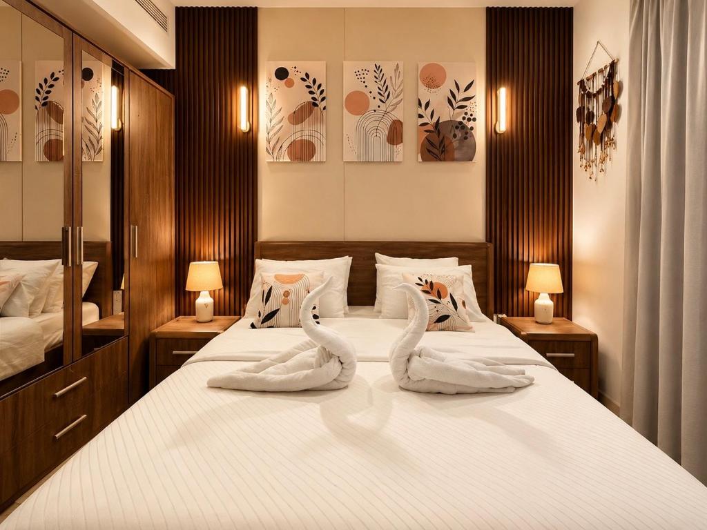 two swans towels on a bed in a bedroom at Beachfront Apartment with Pool & Stunning View in Salalah