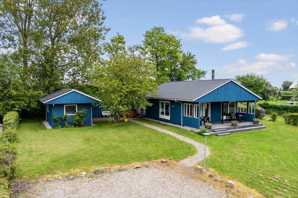 a blue house with a yard at 40583-Juelsminde-Pot-Strandby-119 in Sønderby