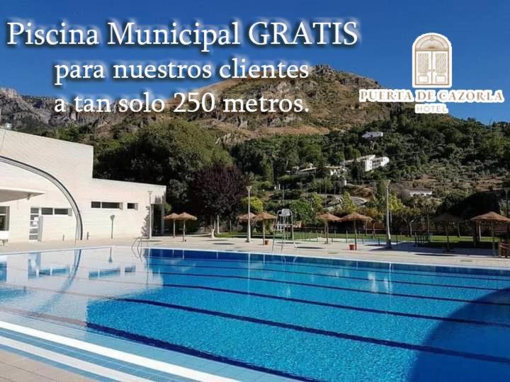 a large swimming pool in front of a building at Hotel Puerta de Cazorla in Cazorla