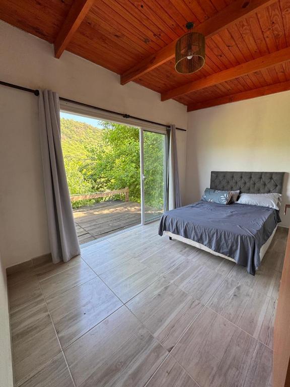 a bedroom with a bed and a large sliding glass door at Complejo La Cascada San Javier in San Javier