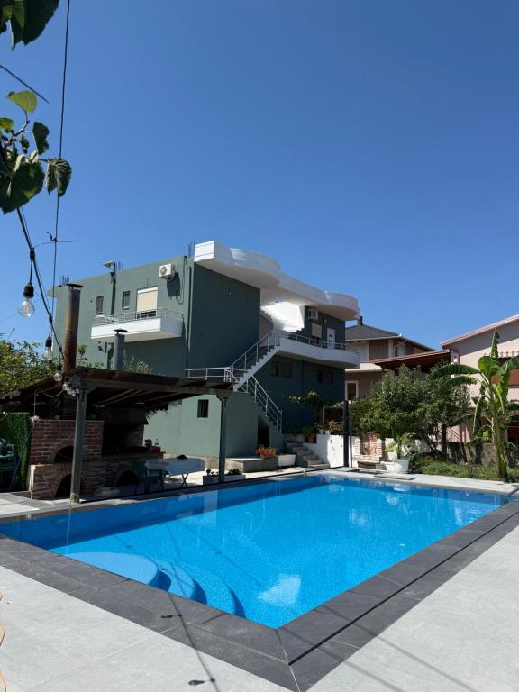 a house with a swimming pool in front of it at Rajan Rooms in Vlorë