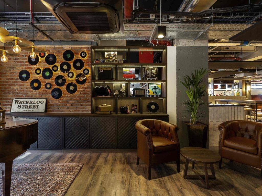 a restaurant with two chairs and a wall with records at ibis Styles Glasgow Central in Glasgow
