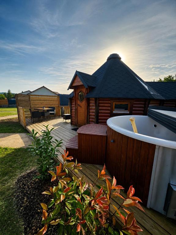 a large wooden cabin with a bath tub in a yard at Le Clos des Chenevières in Rainville