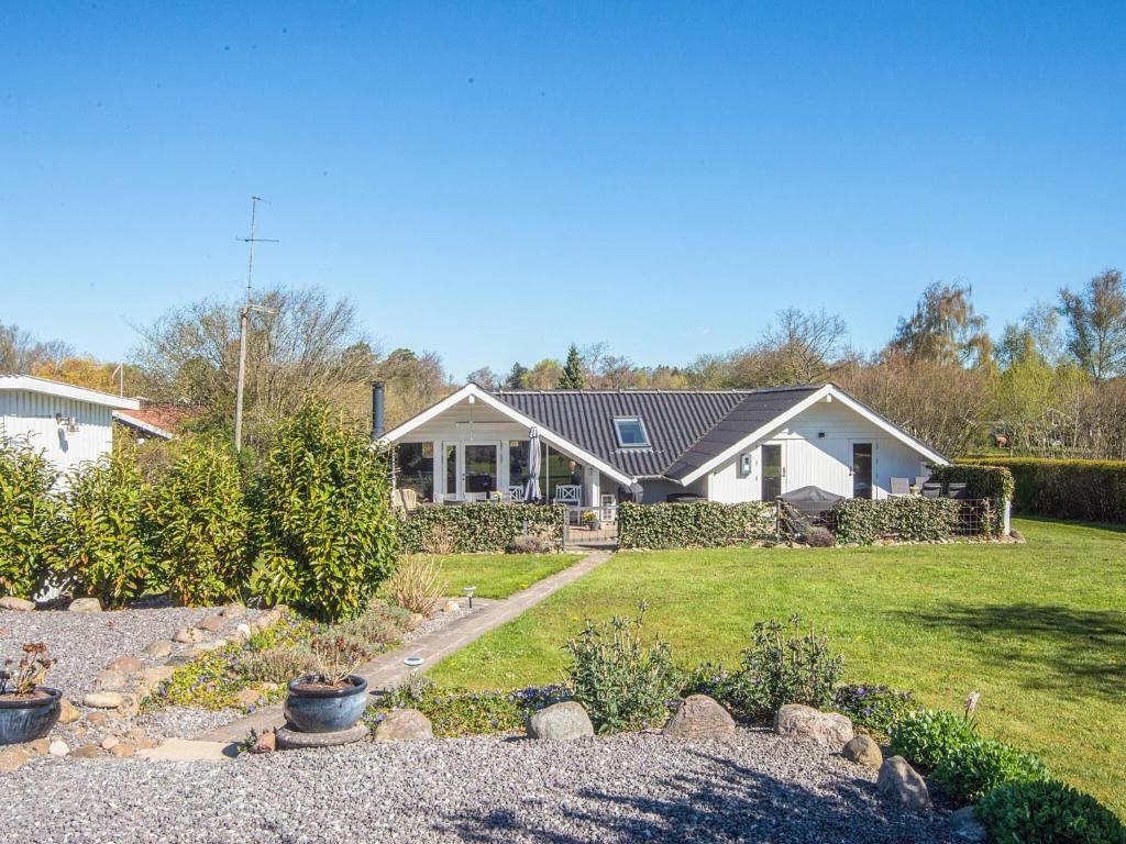 a white house with a yard with a house at 4 star holiday home in Hejls in Hejls