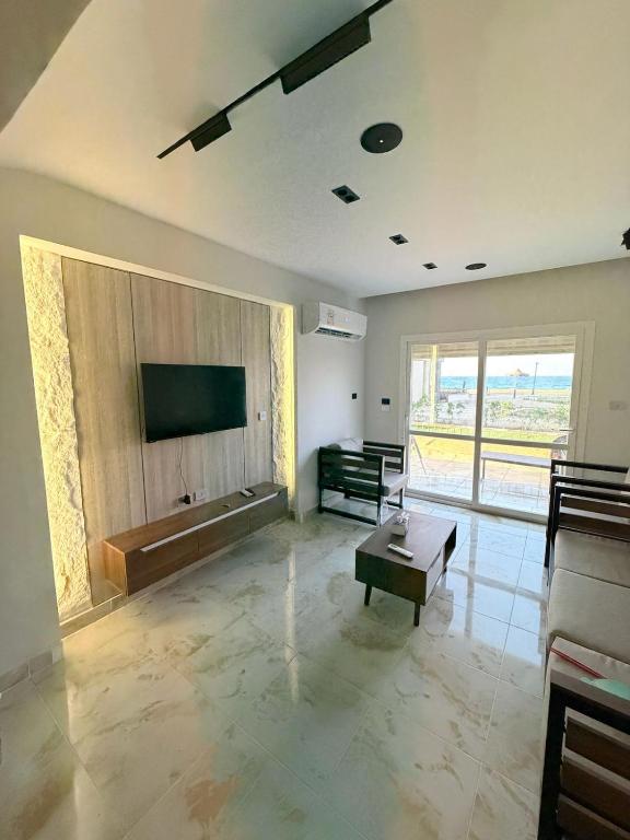 a living room with a flat screen tv and a couch at Coronado Marina in Ain Sokhna