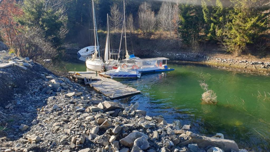 two boats are docked at a dock in a river at Nautic Colibița in Colibiţa