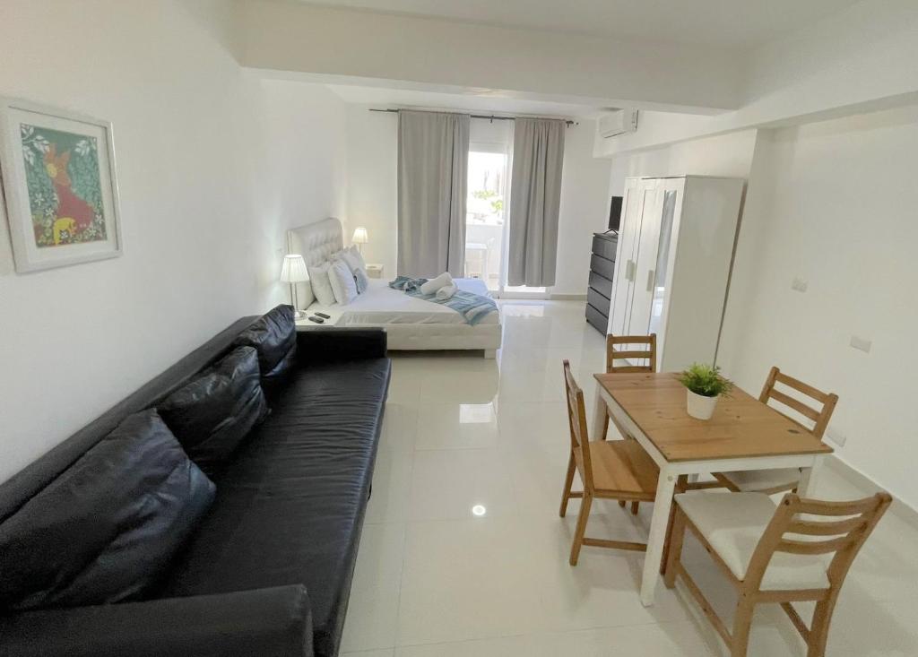 a living room with a black couch and a table at AVENTURA SUITES playa LOS CORALES - great location! in Punta Cana