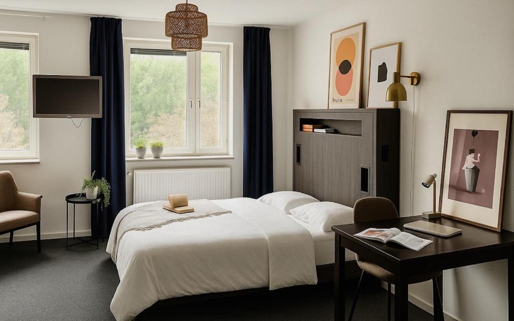 a bedroom with a bed and a desk and a television at Allihoop Ängby Aces in Stockholm