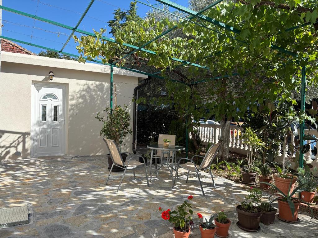 a patio with a table and chairs and potted plants at SM Studio Apartman in Tivat