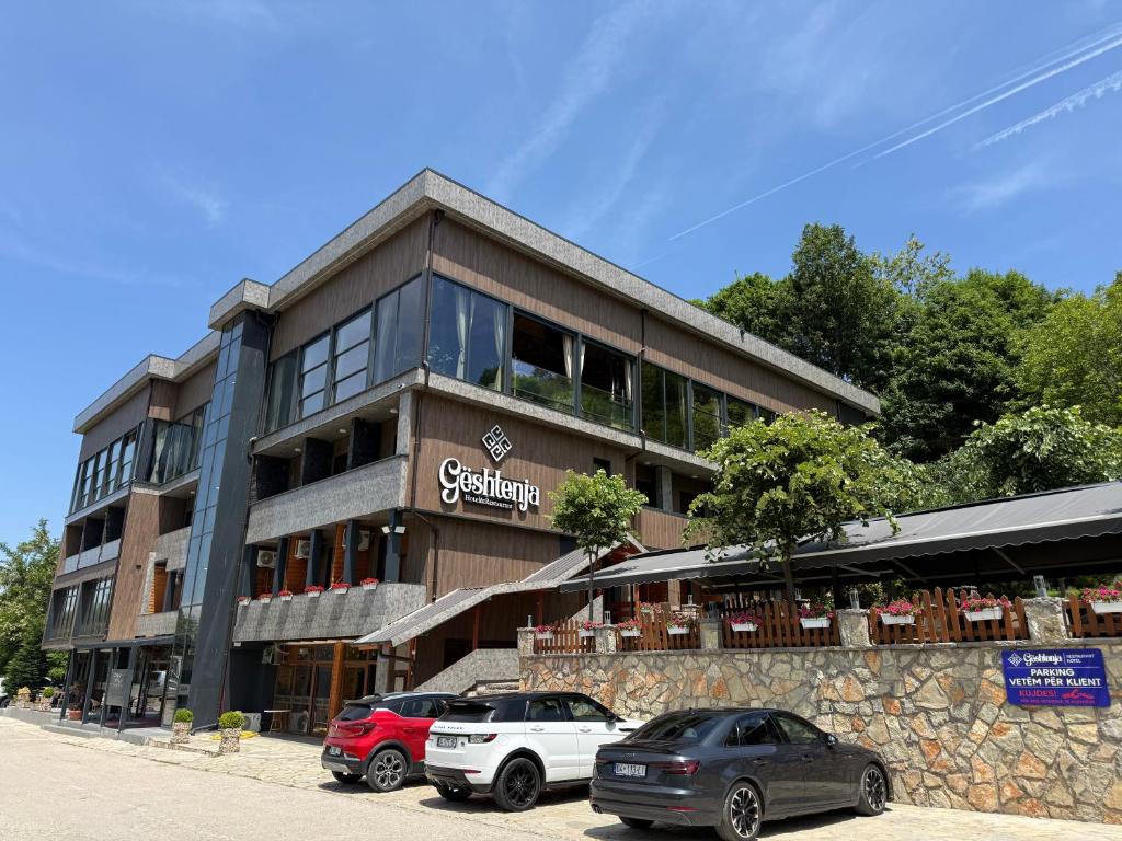 a building with cars parked in front of it at HotelRestaurant Gështenja in Suharekë