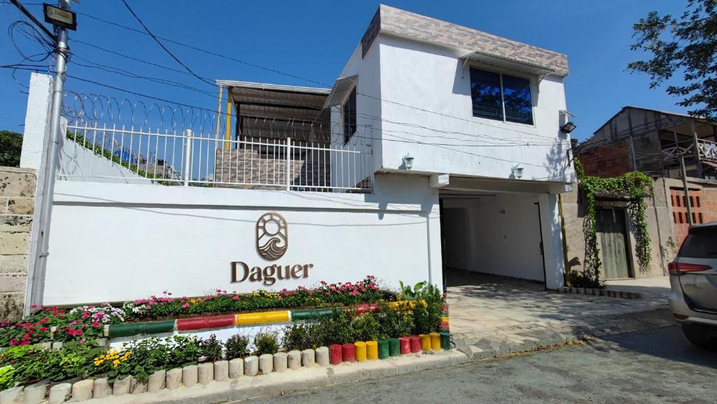 a white building with a sign that reads dagster at Casa Daguer Beach House in Cartagena de Indias