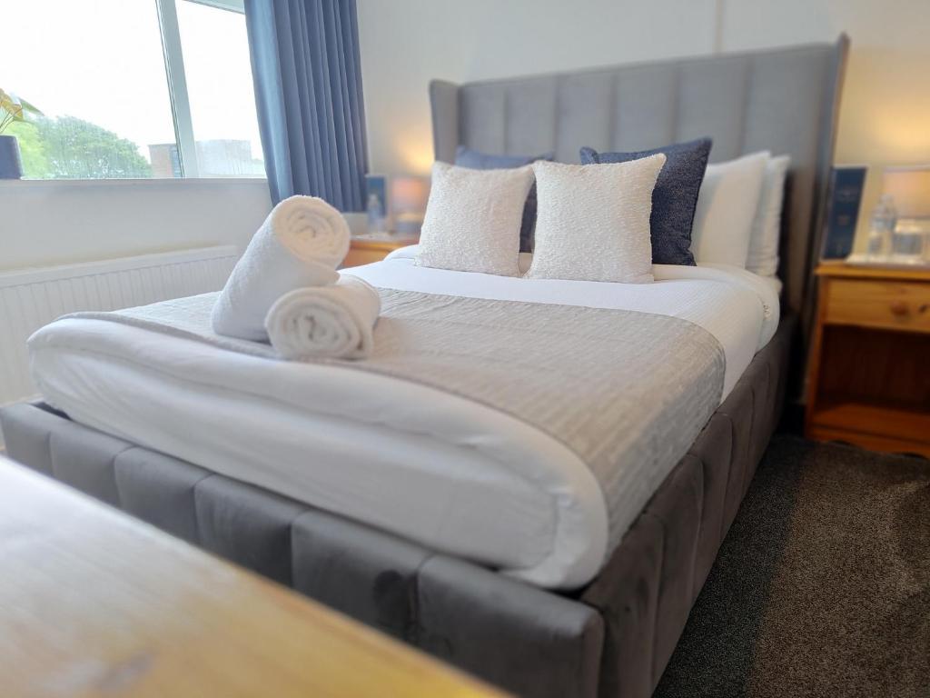 ein Schlafzimmer mit einem großen Bett, auf dem Handtücher liegen in der Unterkunft Windsor Local in Haverfordwest