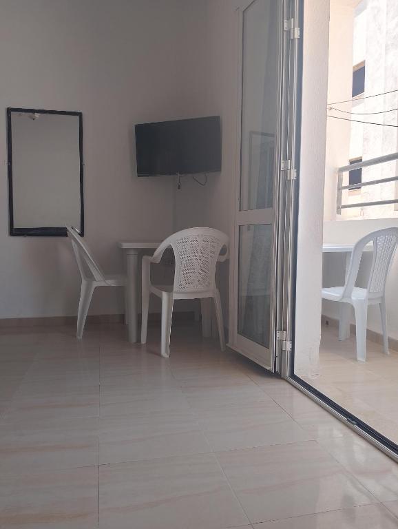 a living room with a table and chairs and a tv at Morgan Appartements in Hammam Sousse