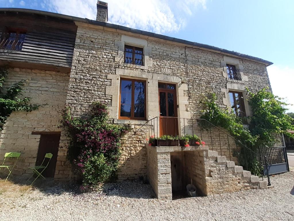 a brick house with flowers in front of it at LE SOURCIER in Argançon