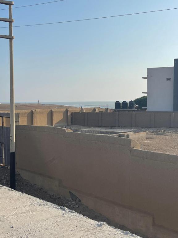 a concrete wall next to a building with a sign at Pacasmagic Surf&Kite in Pacasmayo